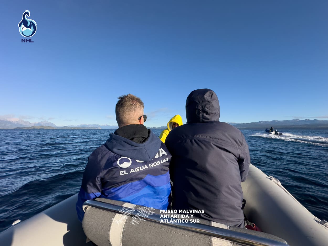 Tripulantes de una lancha de OWA acompañando el cruce, con la cordillera al frente