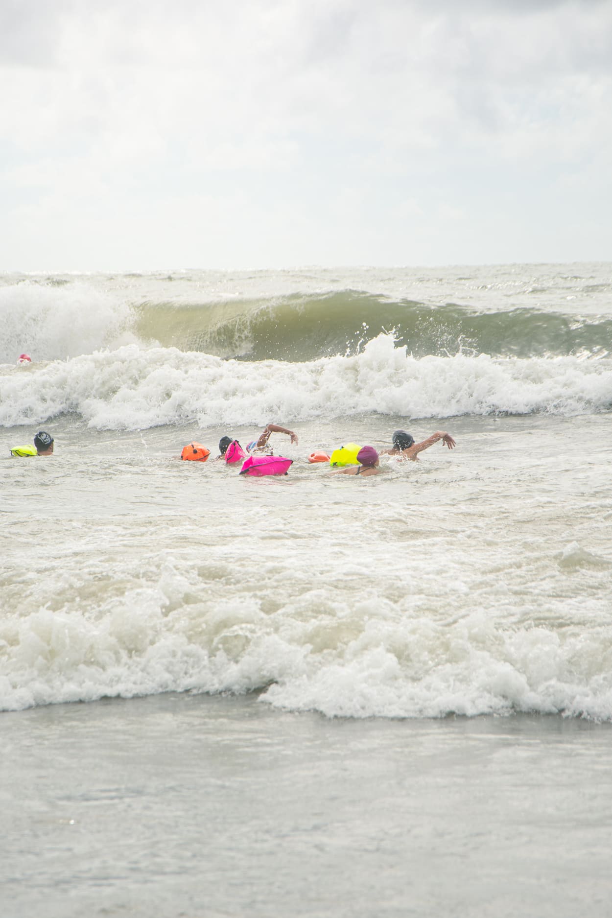 Nadadores cruzando una ola rompiente en el mar de Pinamar