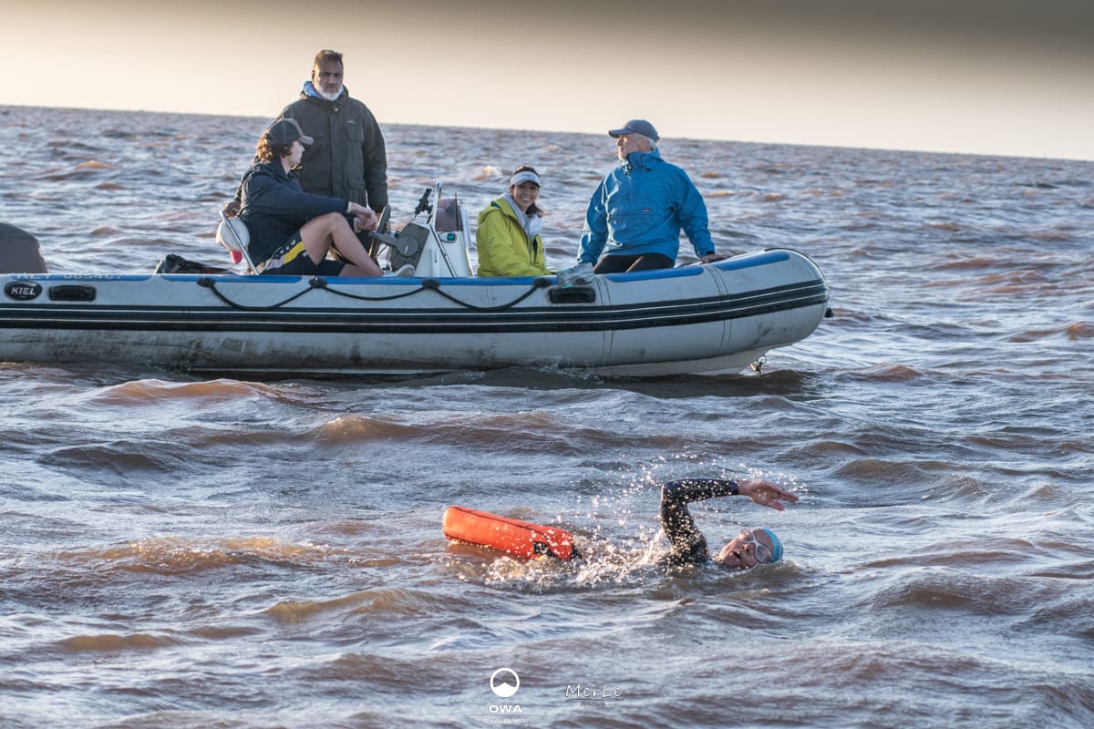 Nadador y embarcación de apoyo en el cruce del Río de la Plata
