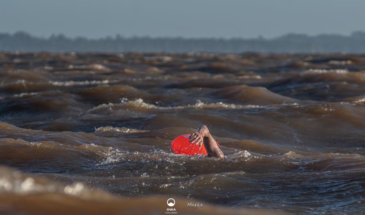 Nadador acompañado por la embarcación de apoyo en el Río de la Plata