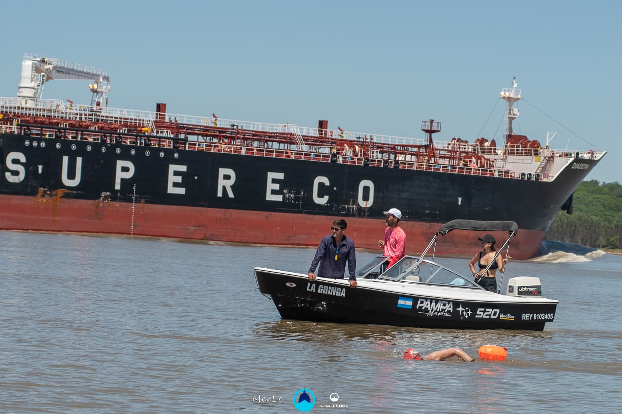 Nadador acompañado por la lancha de apoyo en el Paraná