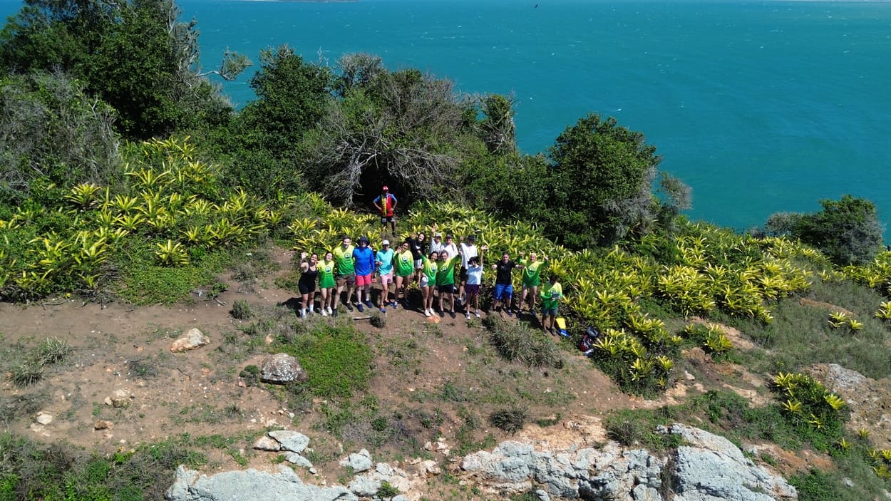Grupo de nadadores reunido en la cima de una isla frente al mar