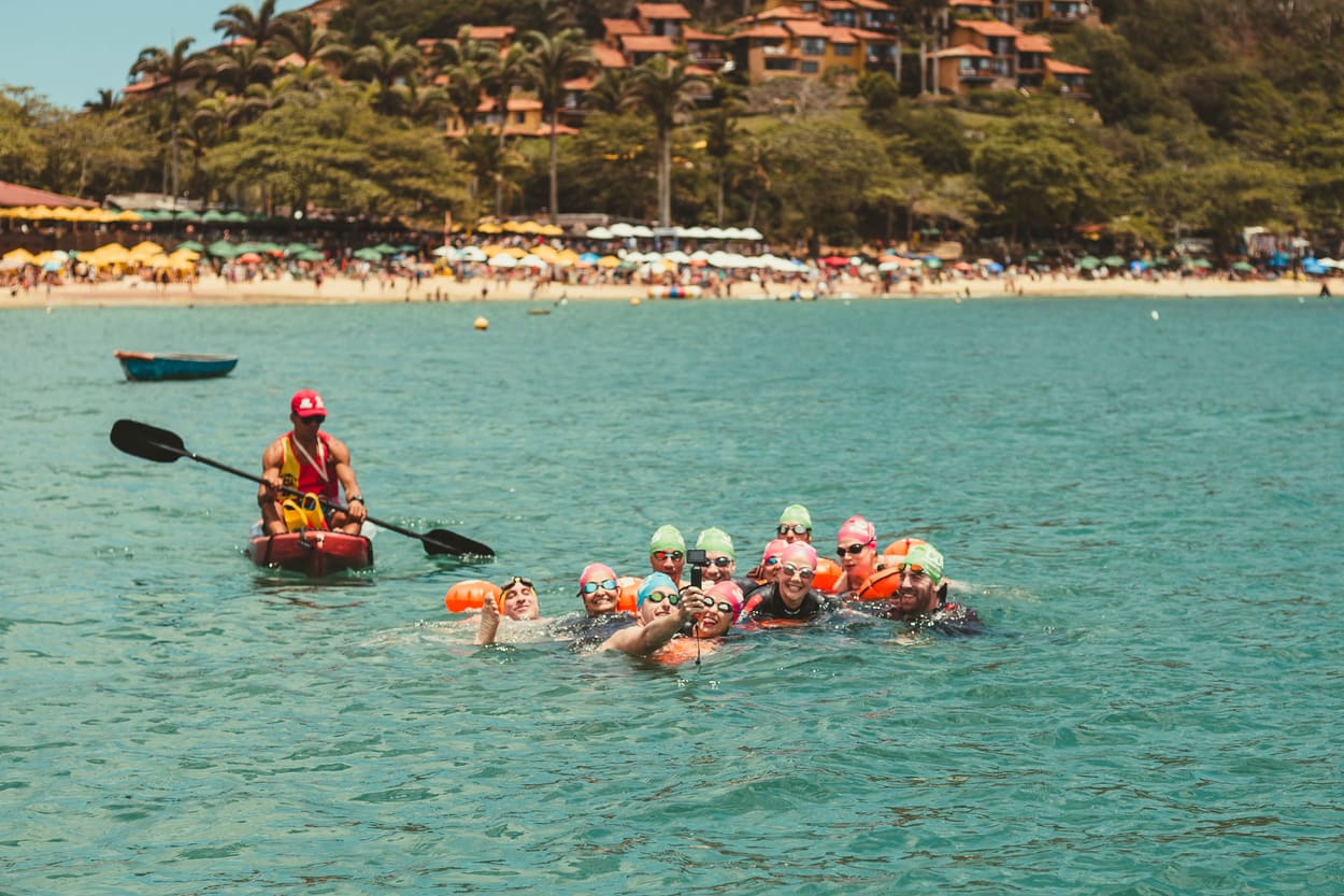Kayak de apoyo acompañando a los nadadores frente a la costa